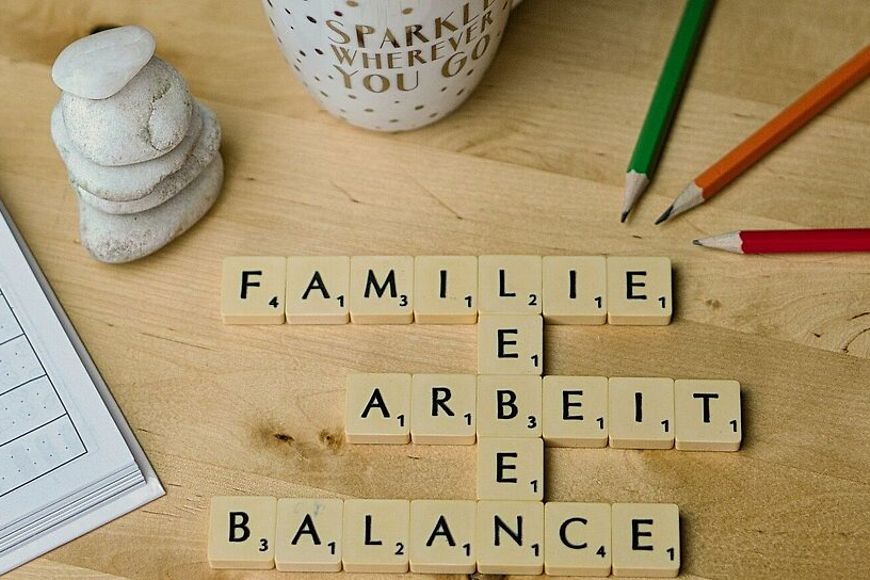 Die Worte Familie, Leben, Arbeiten und Balance sind mit Scrabble Steinen gelegt.