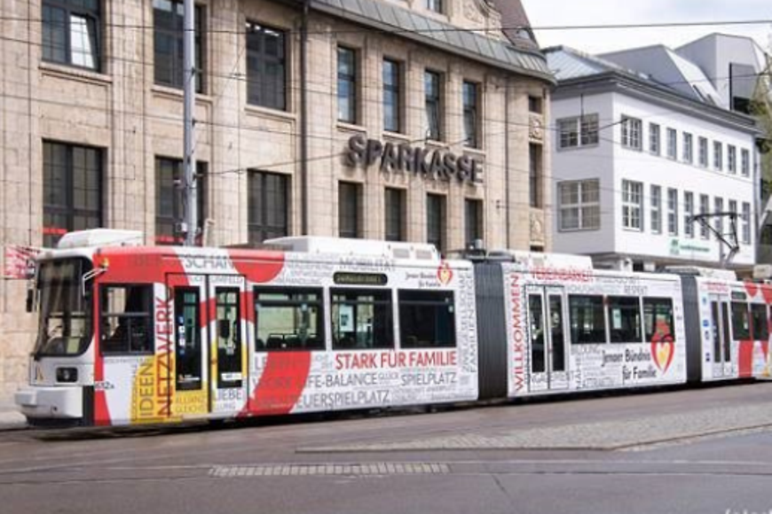 Eine Straßenbahn vor einem Gebäude mit der Aufschrift "Sparkasse"