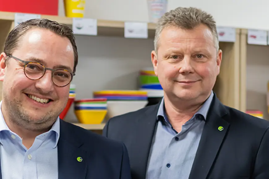 Zwei Männer stehen nebeneinander und schauen in die Kamera