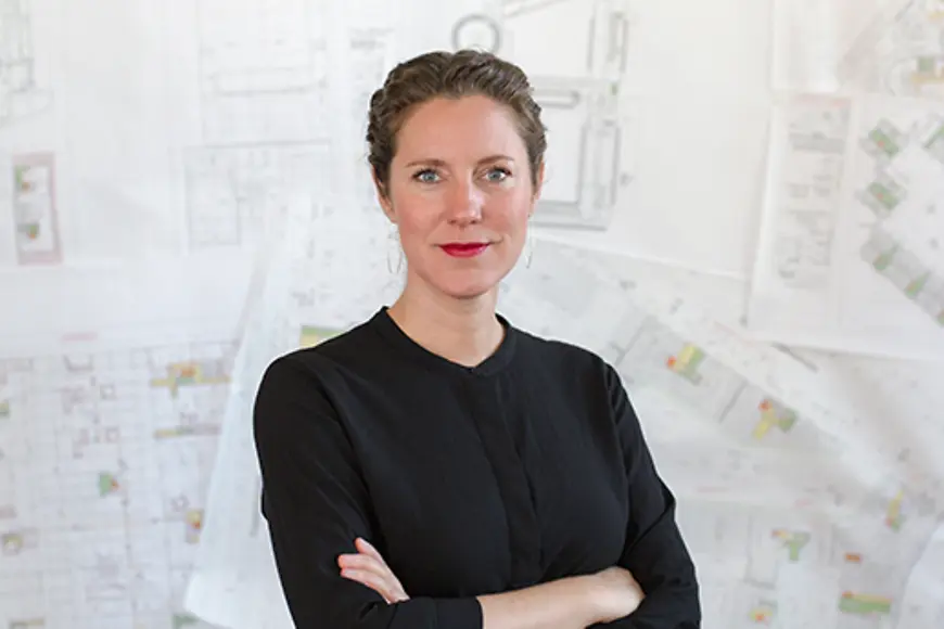 Eine Frau mit verschränkten Armen schaut in die Kamera