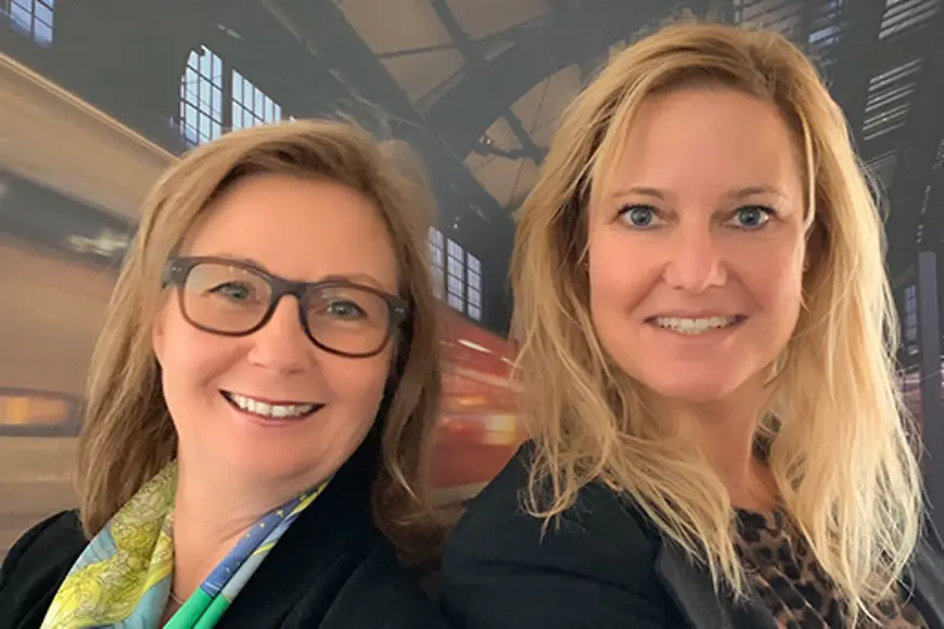 zwei Frauen stehen nebeneinander und schauen in die Kamera