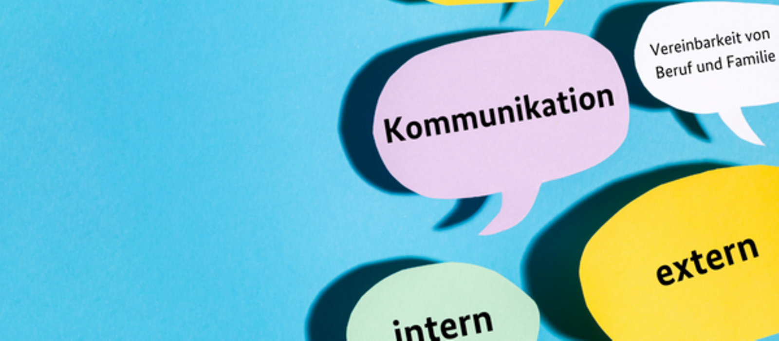 Bunte Sprechblasen mit Schriftzügen wie "Kommunikation" und "extern"