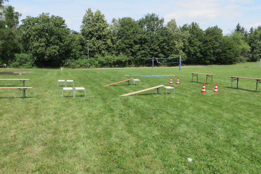 Rasenfläche mit Bänken Tischen und Verkehrskegeln