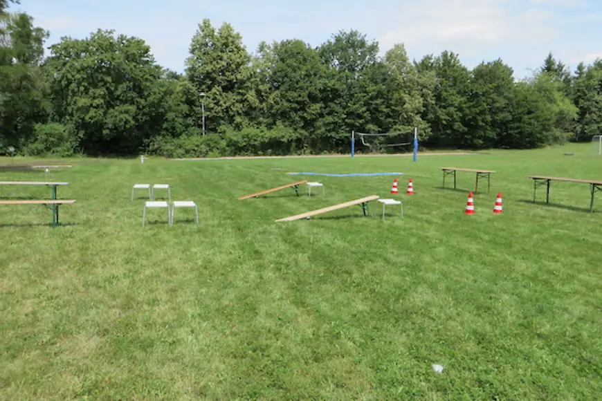 Rasenfläche mit Bänken Tischen und Verkehrskegeln