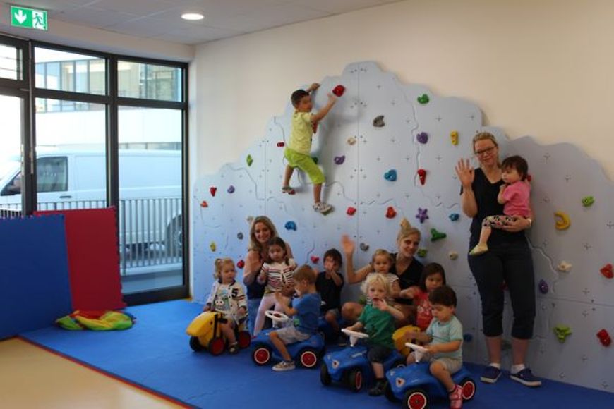 Kinder und drei Frauen vor einer Klettwerwand