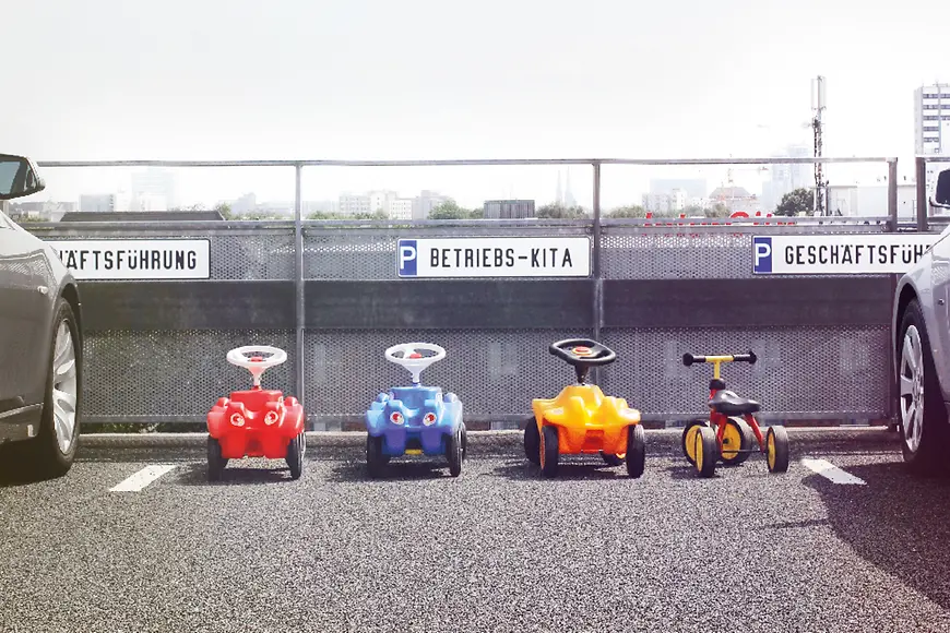 Tretautos auf einem Parkplatz für eine Betriebs-Kita
