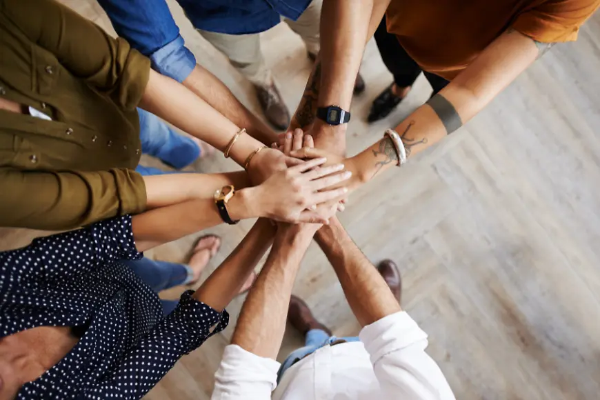 Menschen legen die Hände übereinander 