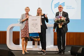 Zu sehen sind BMin Karin Prien und DIHK-Präsident Peter Adrian bei der Urkundenübergabe an die Messe München