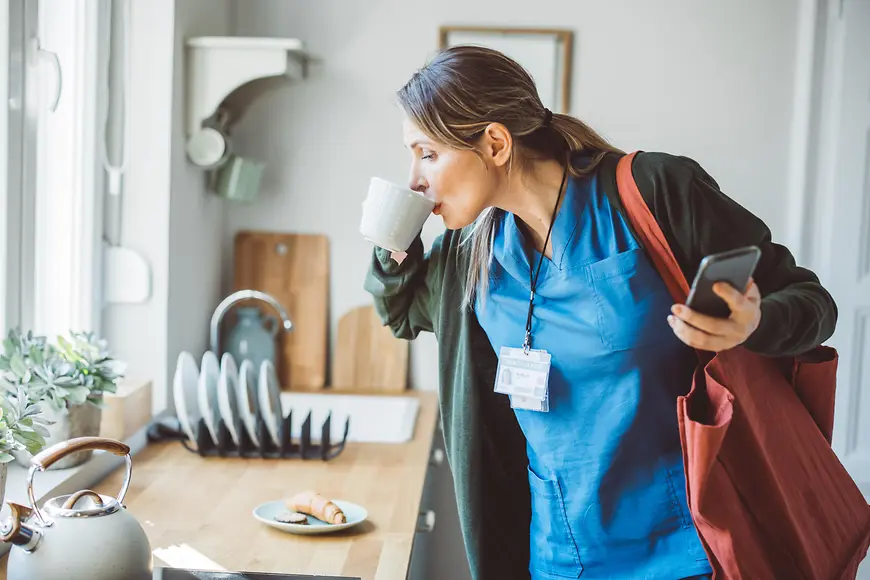 Eine Frau trinkt eine Tasse Kaffee in der Küche